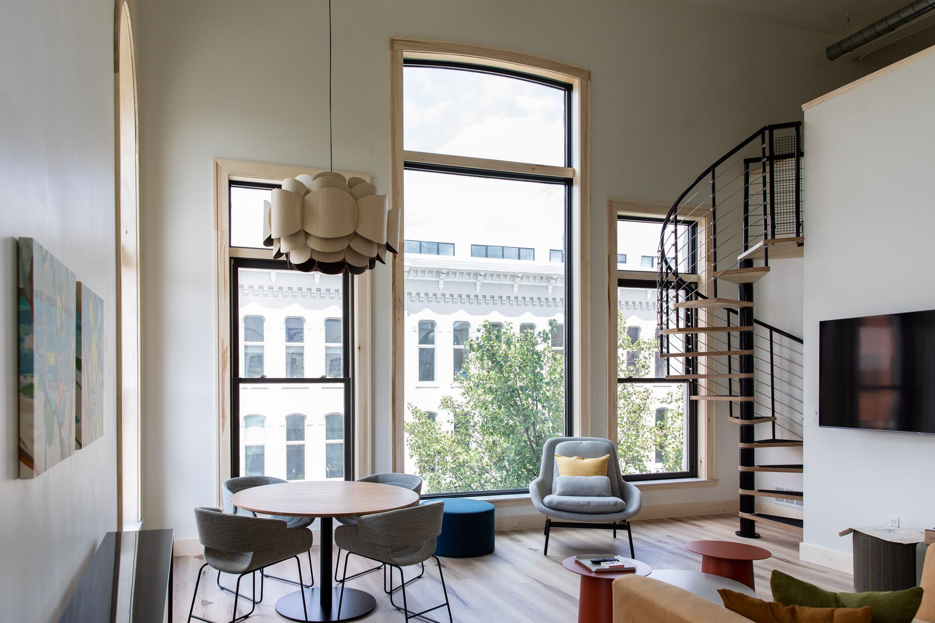 A living room with a spiral staircase and lots of windows
