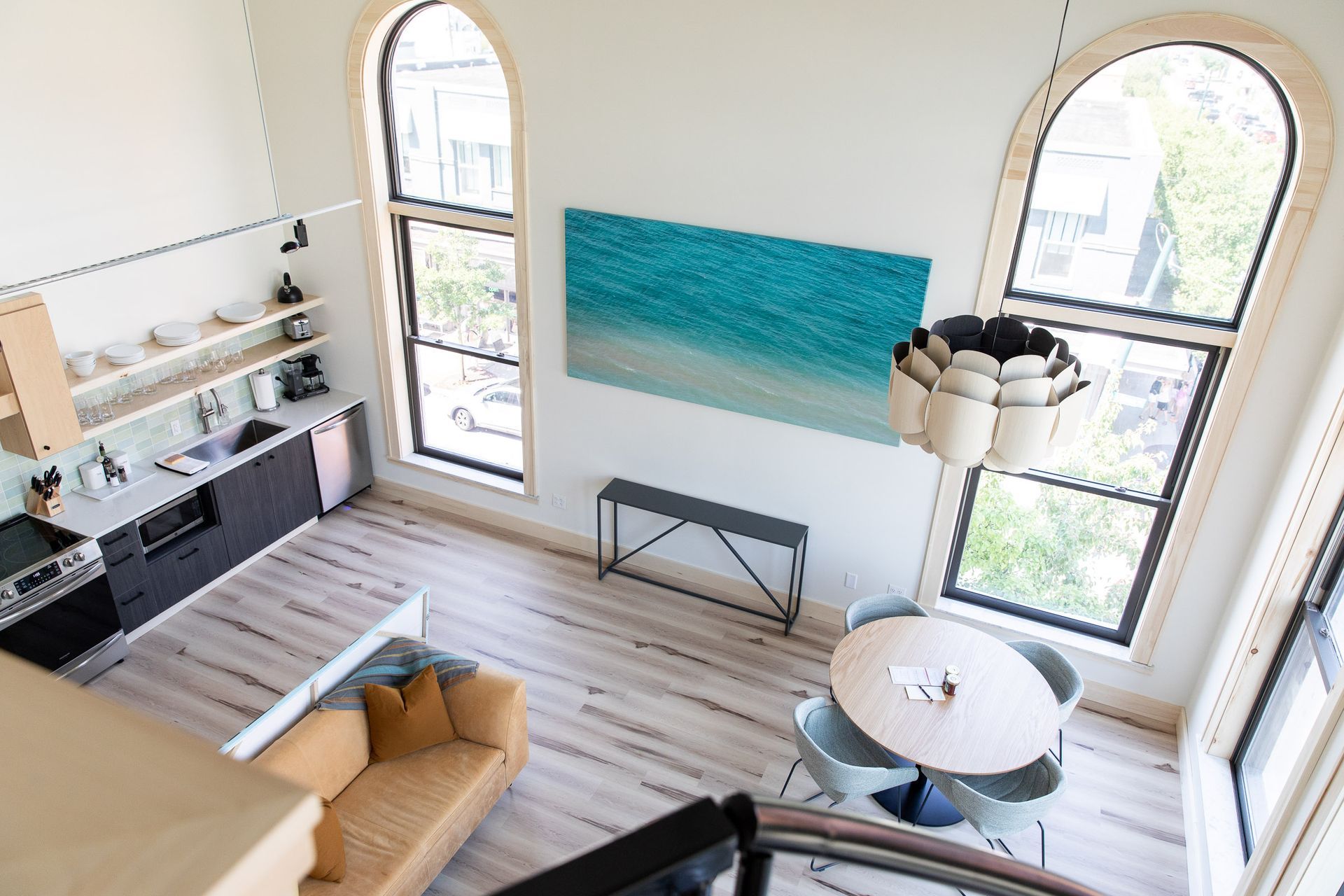 An aerial view of a living room with a couch , table and chairs.