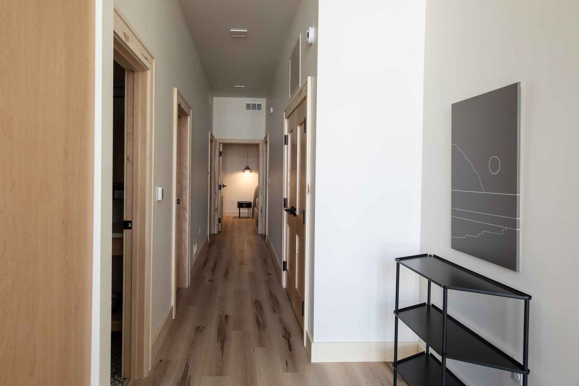 A hallway with a shelf and a picture on the wall