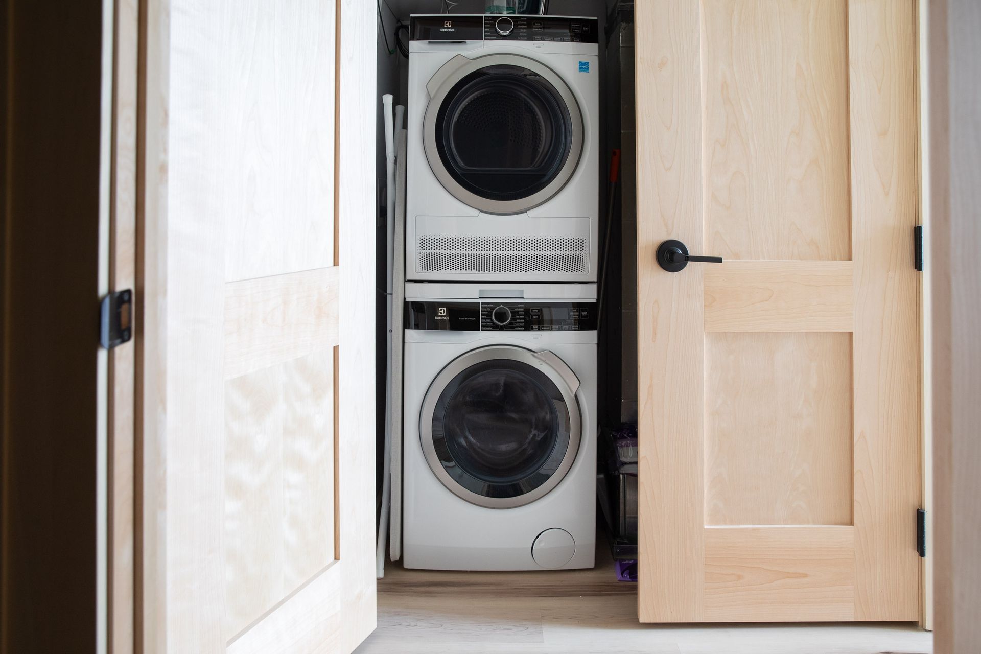 A washer and dryer are stacked on top of each other in a laundry room.