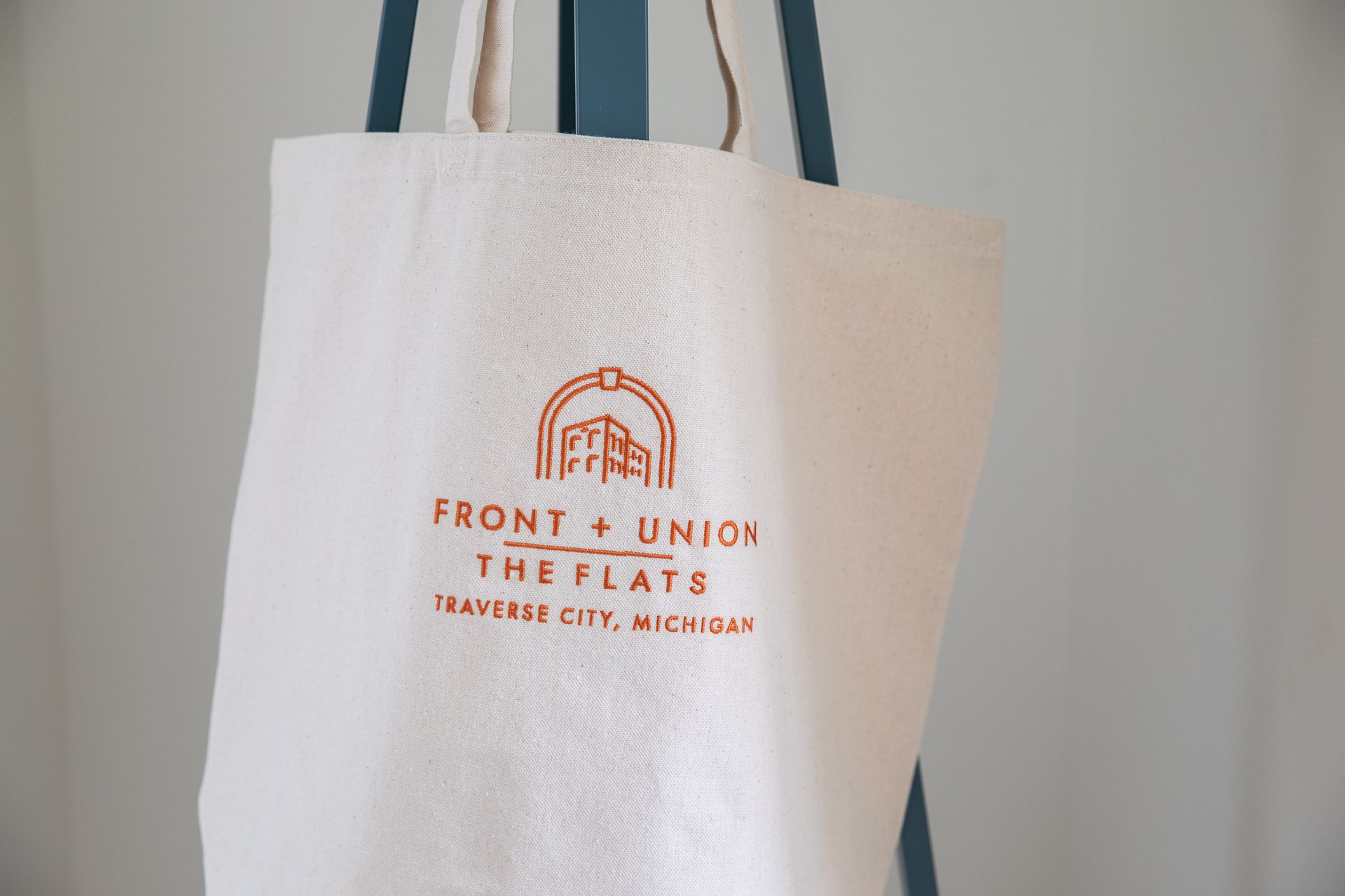 A white tote bag with the words front 4 union the flats on it