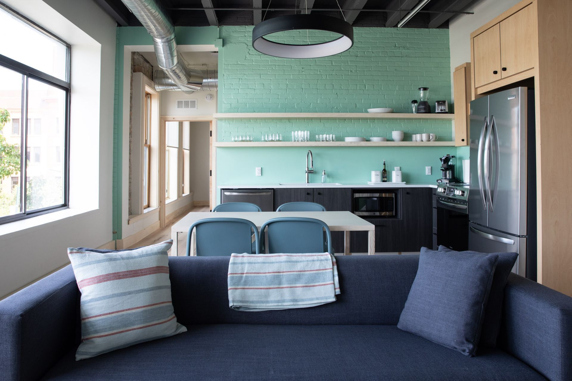 A living room with a couch and a kitchen in the background
