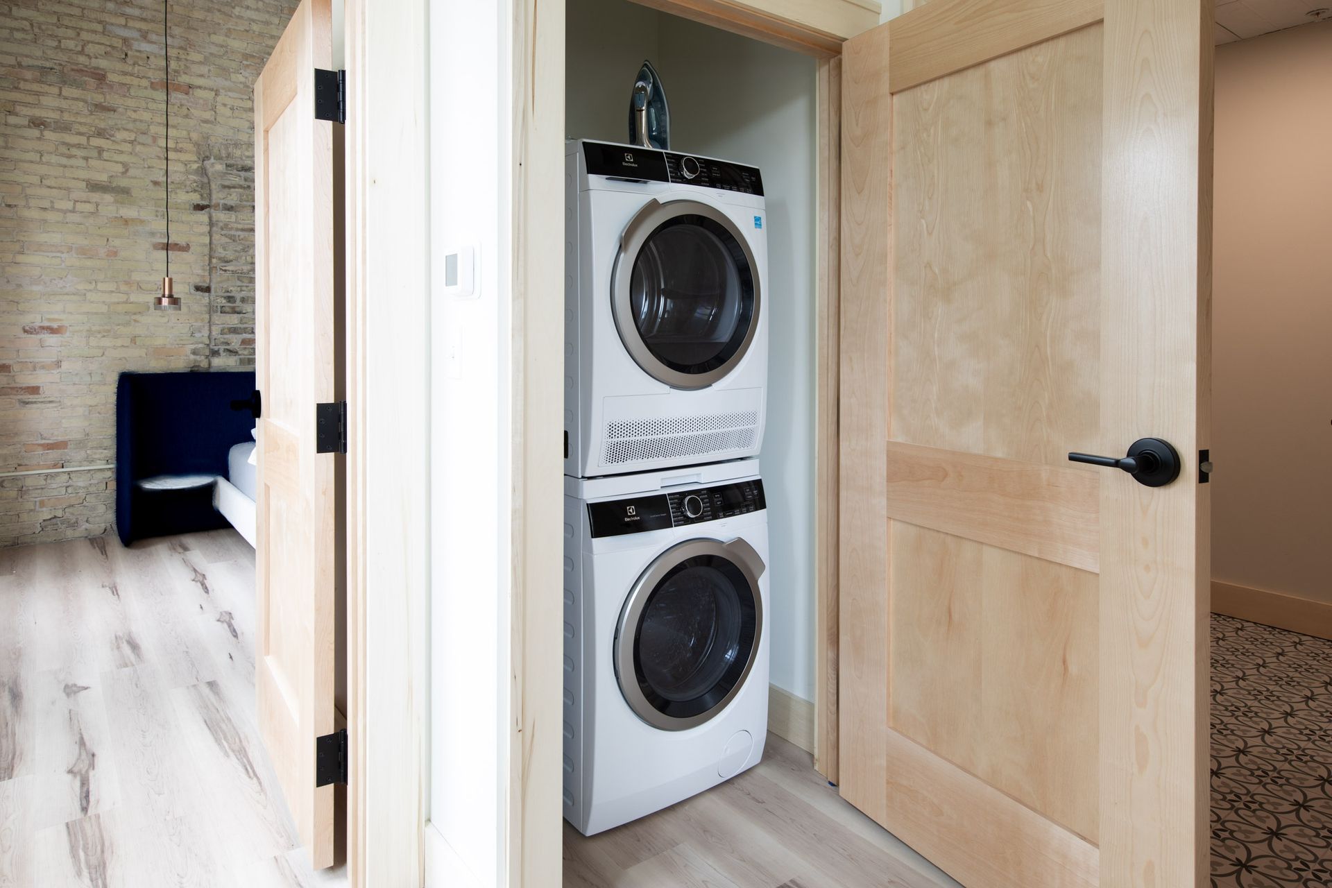 A washer and dryer are stacked on top of each other in a closet.