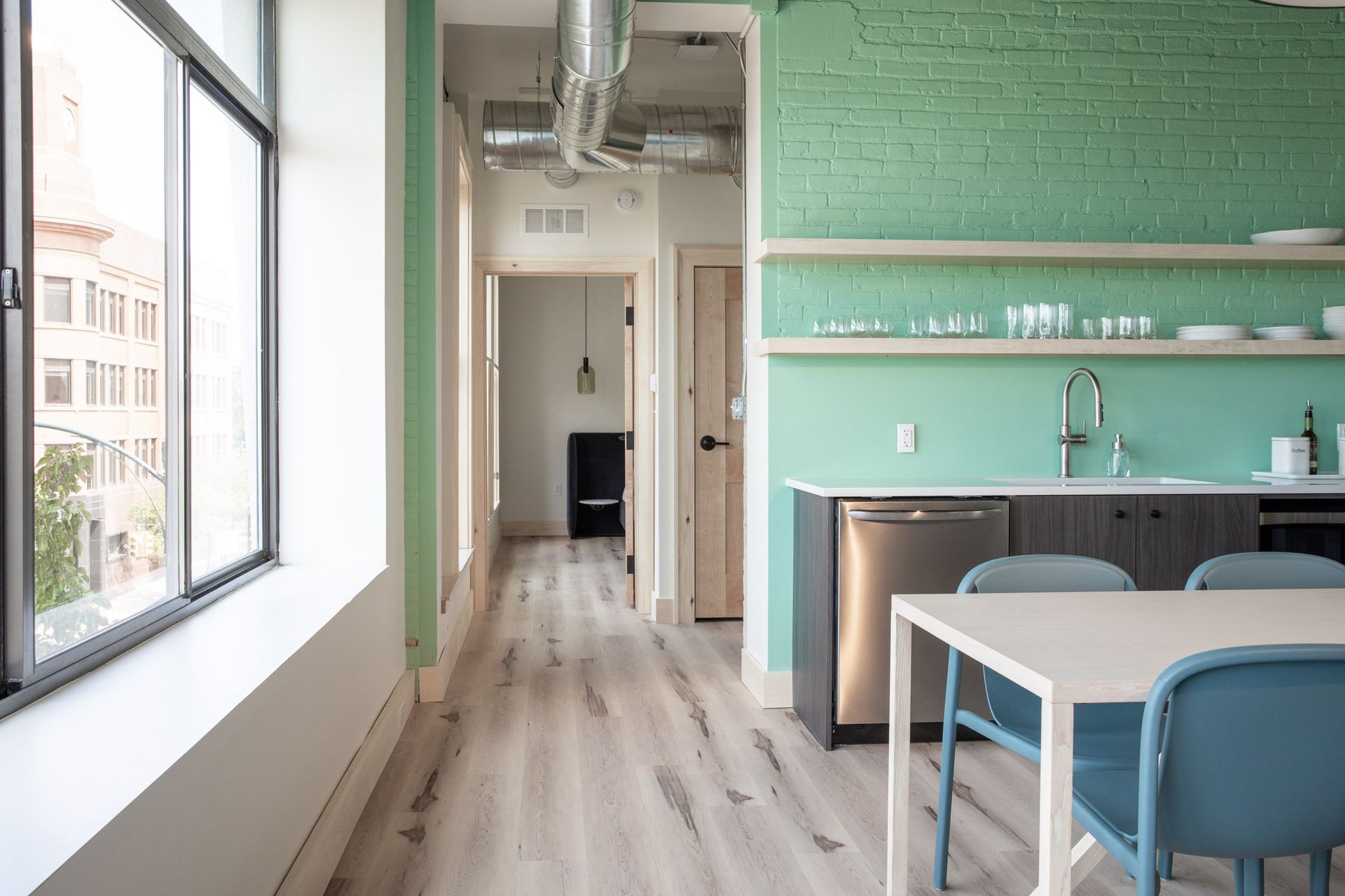 A kitchen with a table and chairs and a green wall.