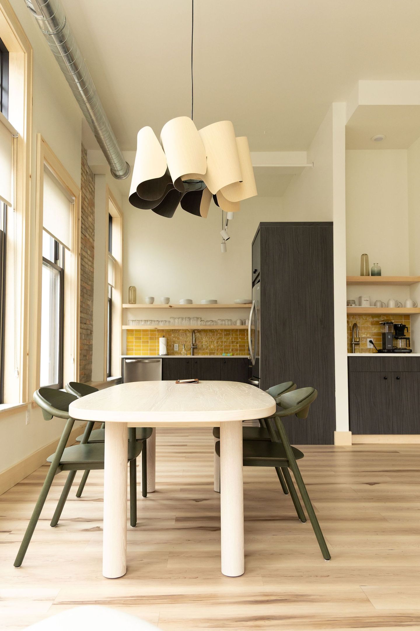 A living room with a couch , table , chairs and a kitchen.