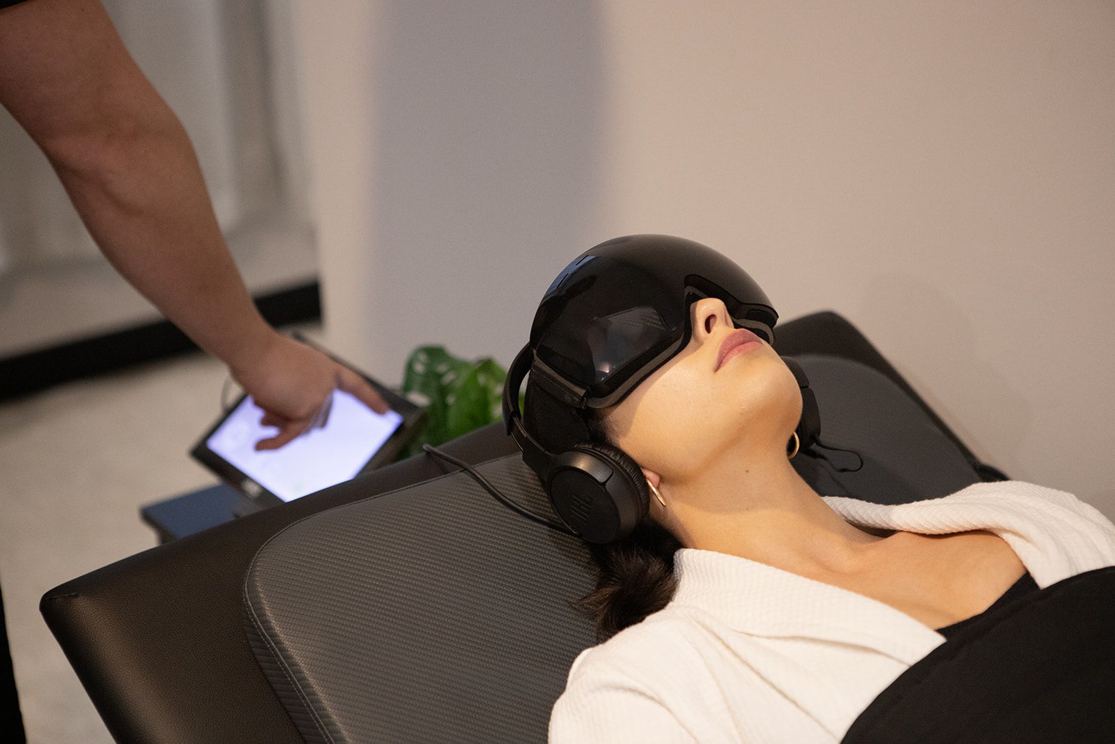 A woman is using a NeoRhythm pulsed electromagnetic field device.