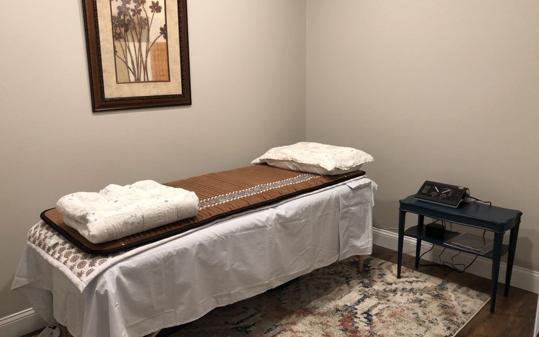 A massage table in a room with a picture on the wall.