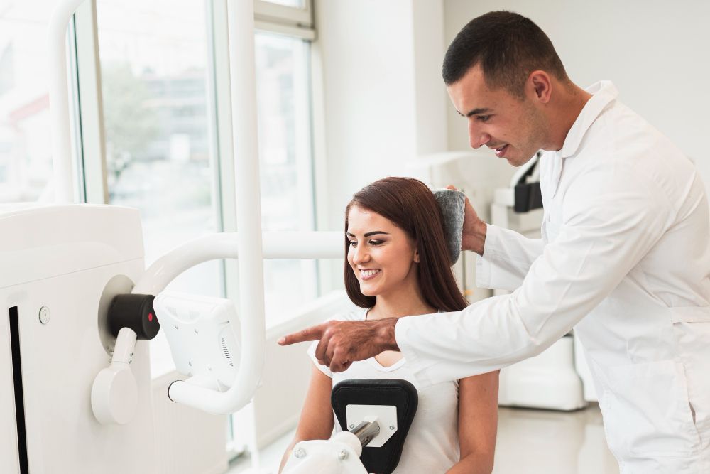 A doctor is talking to a patient in a dental office.