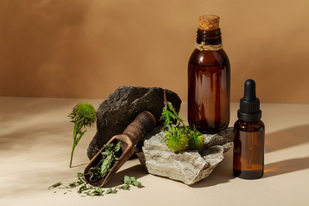 A bottle of essential oil is sitting on top of a rock.