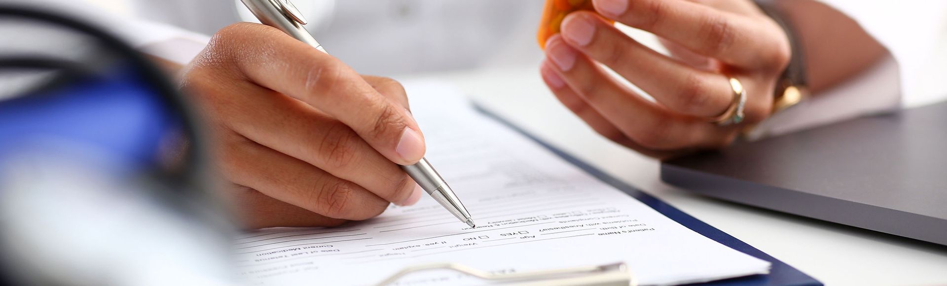 A close up of a person writing on a piece of paper with a pen.