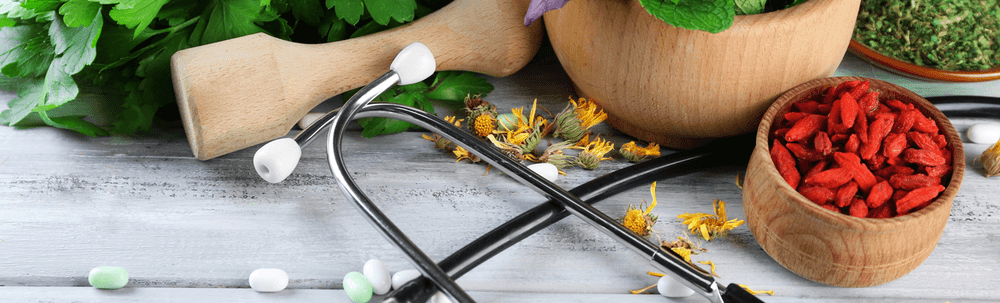 A stethoscope is sitting on top of a wooden table next to a mortar and pestle.