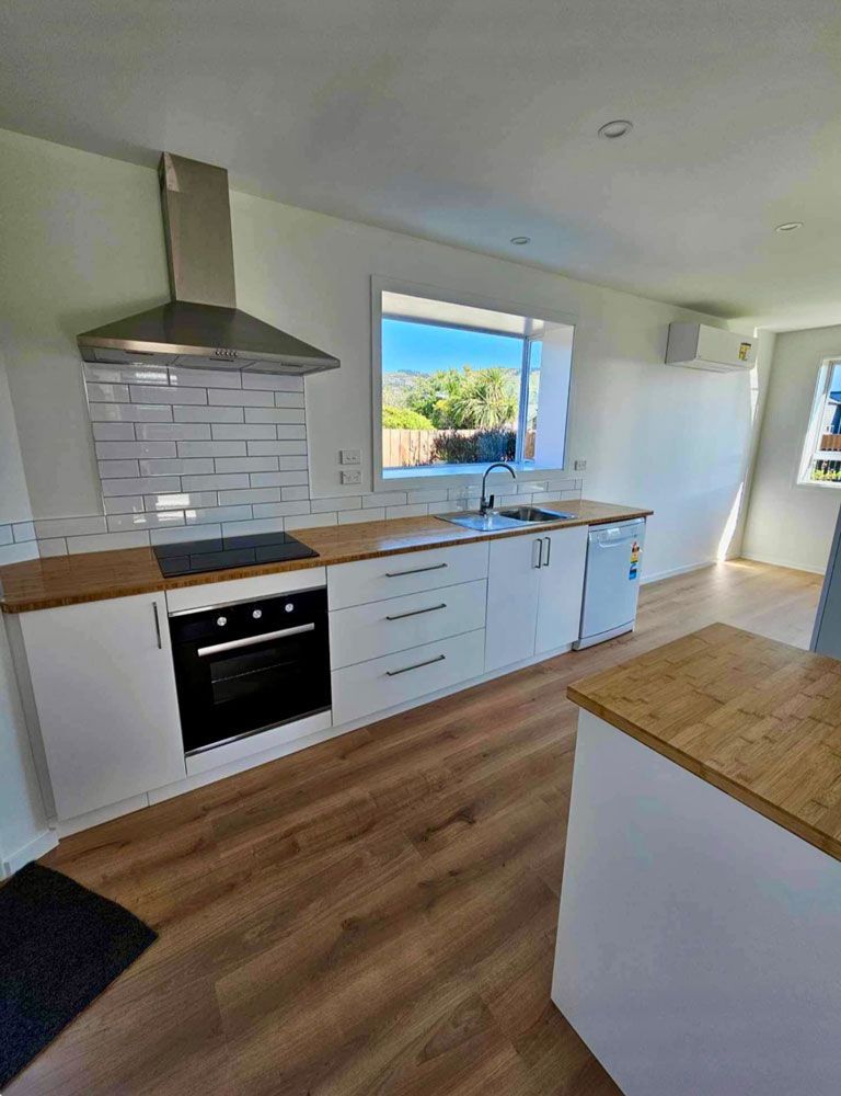 Kitchen with White Cabinets and Wooden Floor — Joinery In Christchurch
