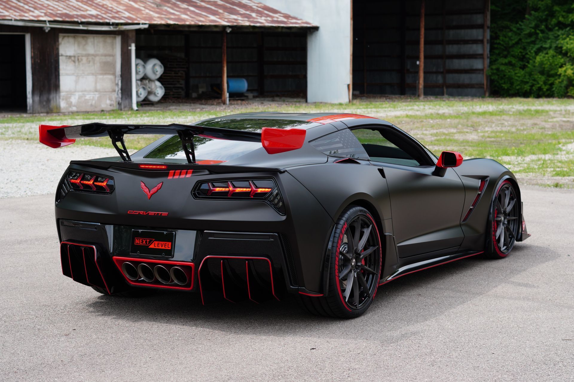 A black and red sports car is parked in front of a building.