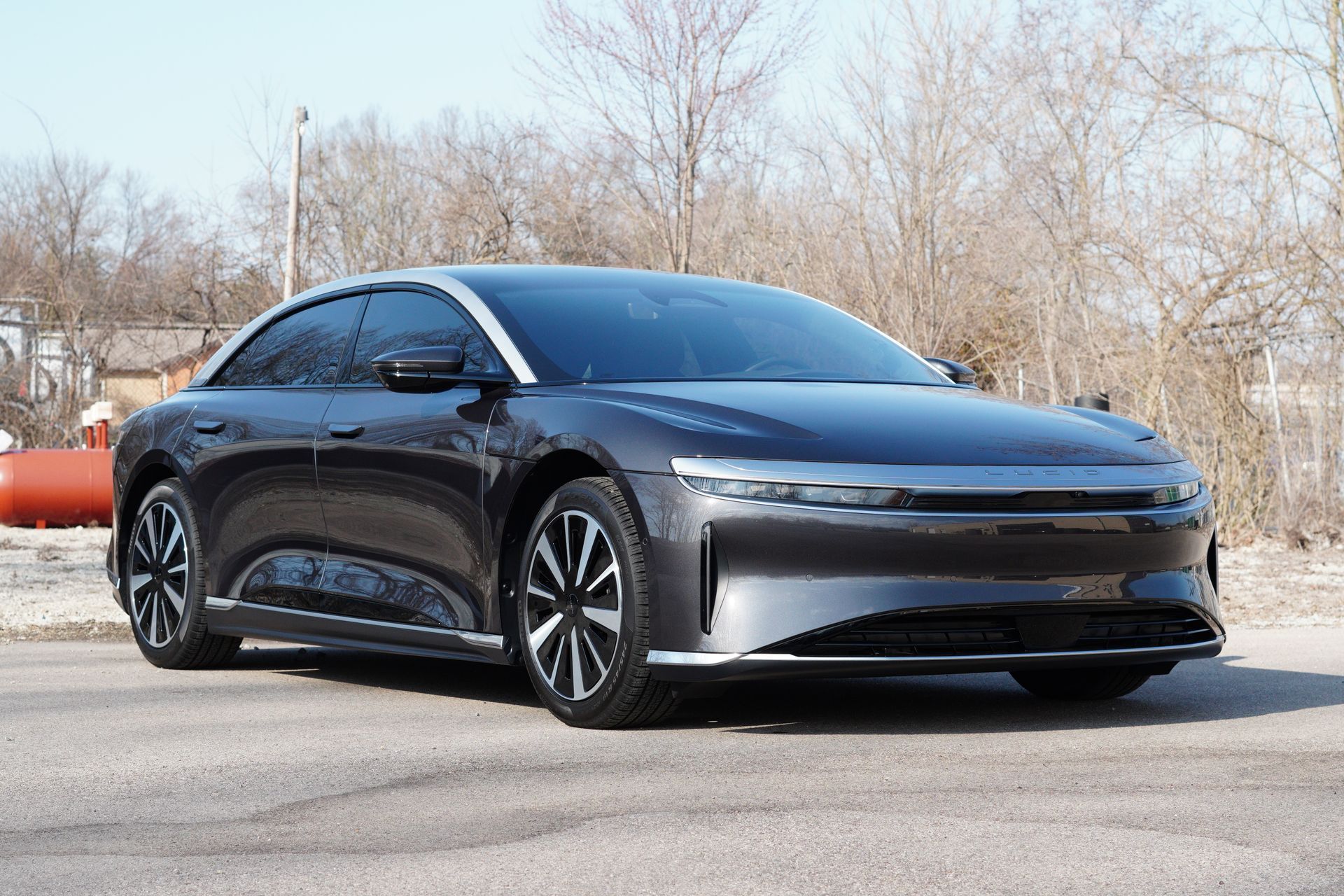 Dark gray Lucid Air electric sedan parked outdoors on pavement.