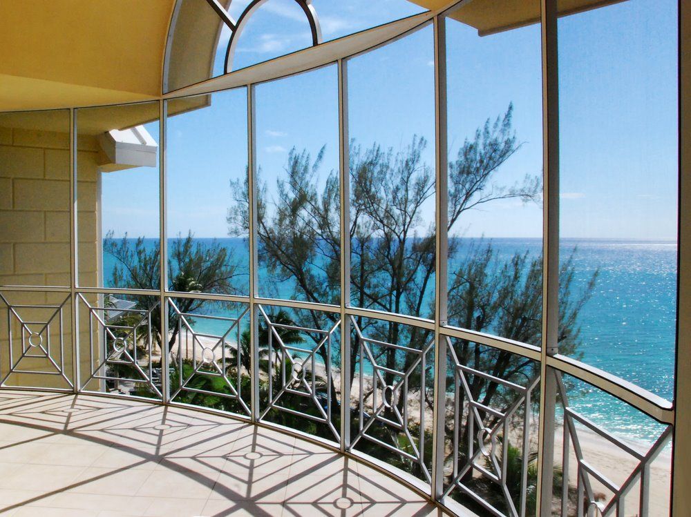 Curved Glass Balcony With Railing Overlooking Sunny Ocean