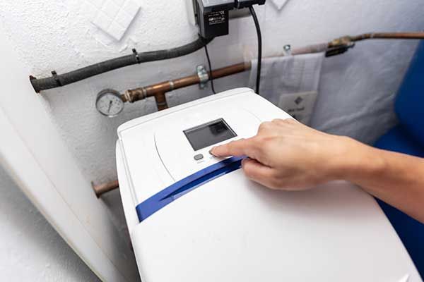 A person is pressing a button on a water softener.