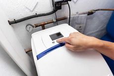 A person is pressing a button on a water softener.
