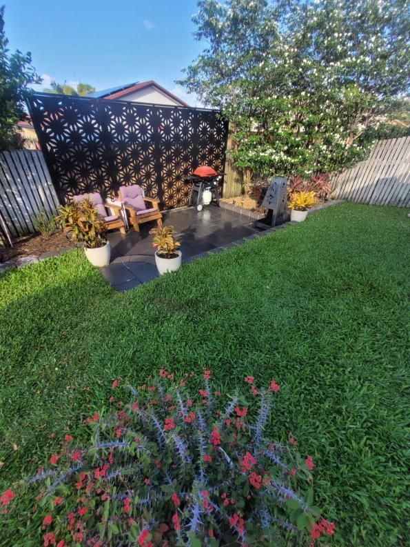 A Backyard With A Fence, Chairs, Potted Plants And Flowers — Bigdog Welding and Fabrication Pty Ltd In Currajong, QLD