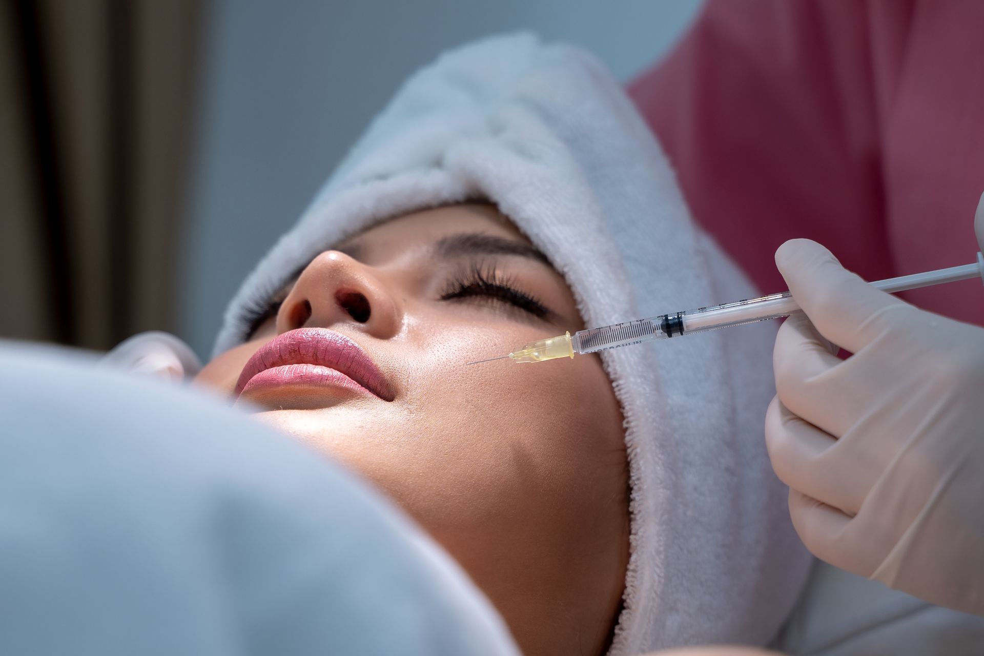 A woman is getting a botox injection in her face.