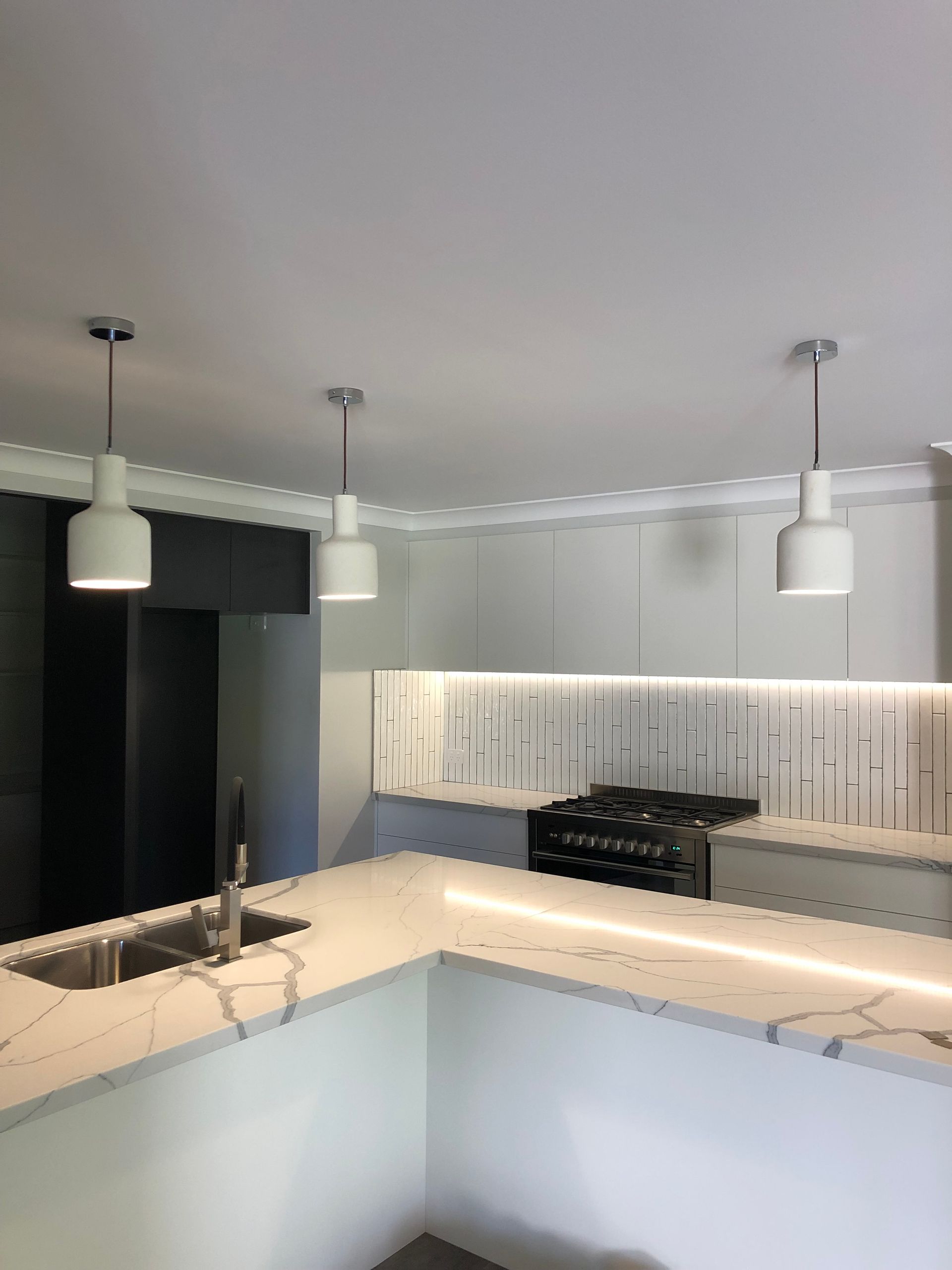 A Kitchen With White Cabinets, a Sink, and a Stove — Brightway Electrical in Ballina, NSW