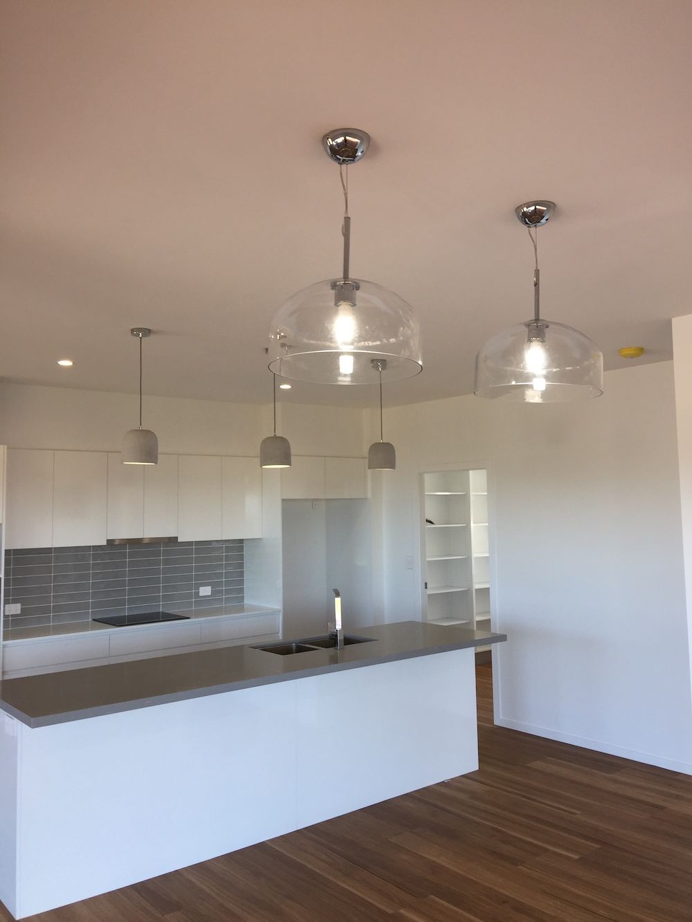 An Empty Kitchen with Hanging Lights — Brightway Electrical in Ballina, NSW