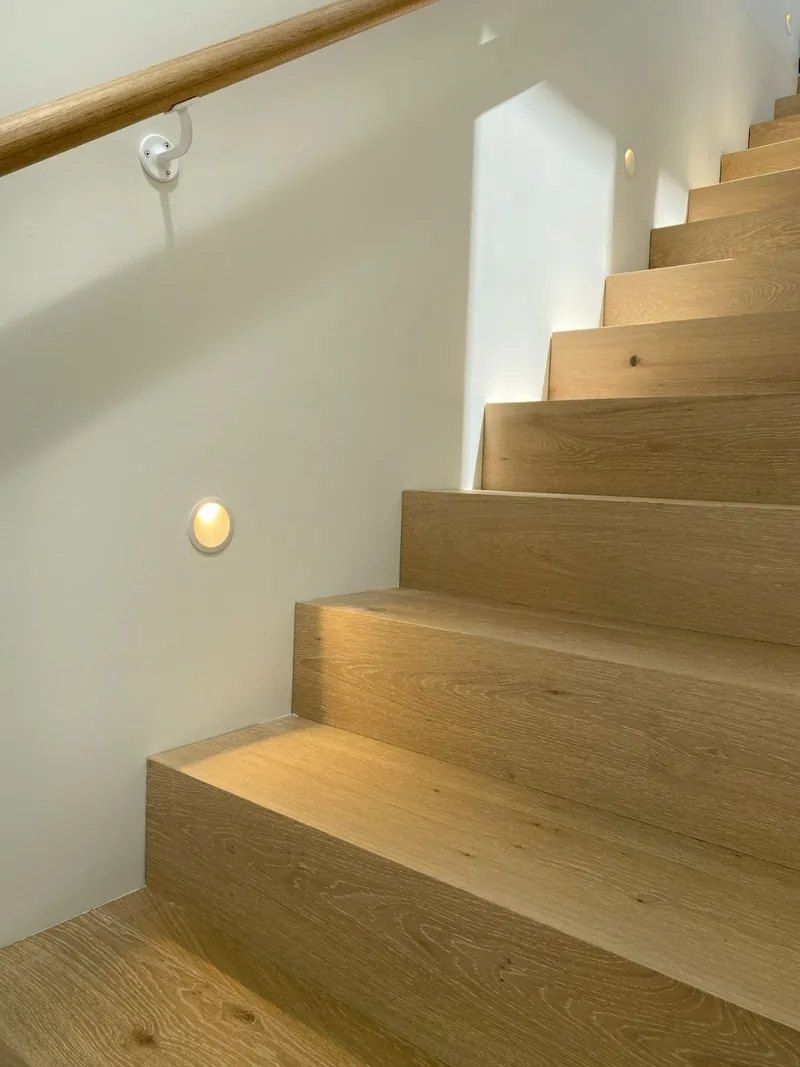 A Close Up of a Wooden Staircase With a Wooden Railing — Brightway Electrical in Ballina, NSW