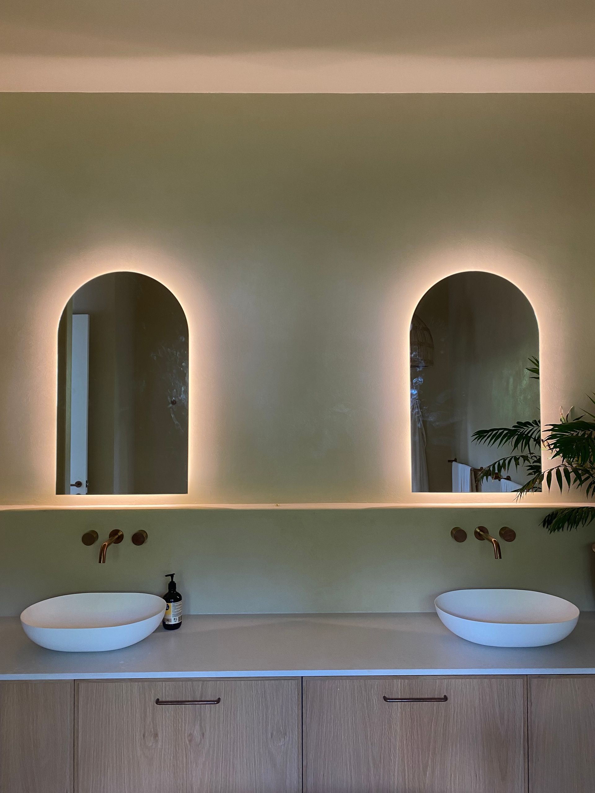 A Bathroom with a Green Wall and Two Mirrors — Brightway Electrical in Ballina, NSW