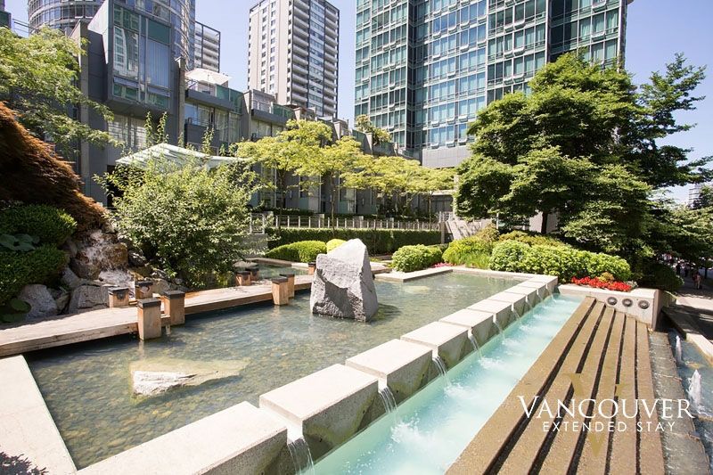 A giant rock on a fountain next to apartment buildings