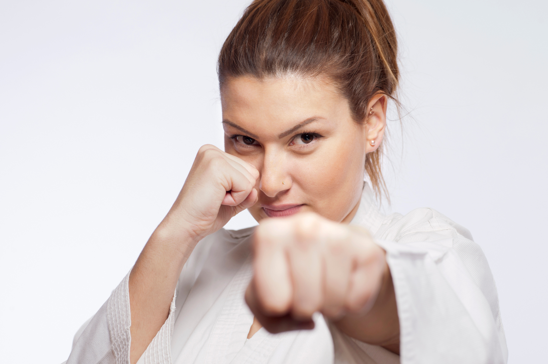 woman in white karate uniform give pose of punching