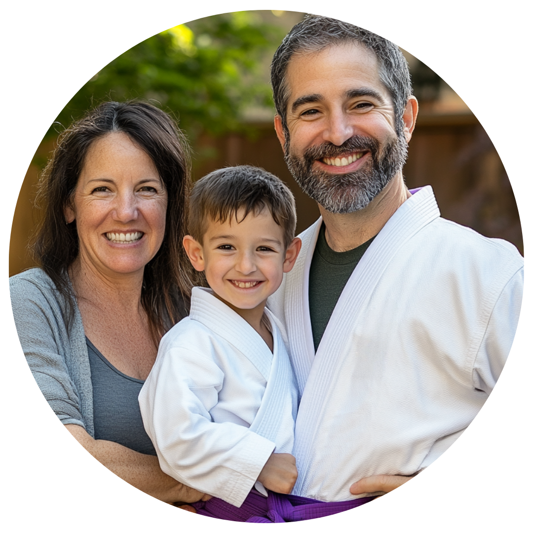 A man and woman are holding a little boy in a karate uniform.