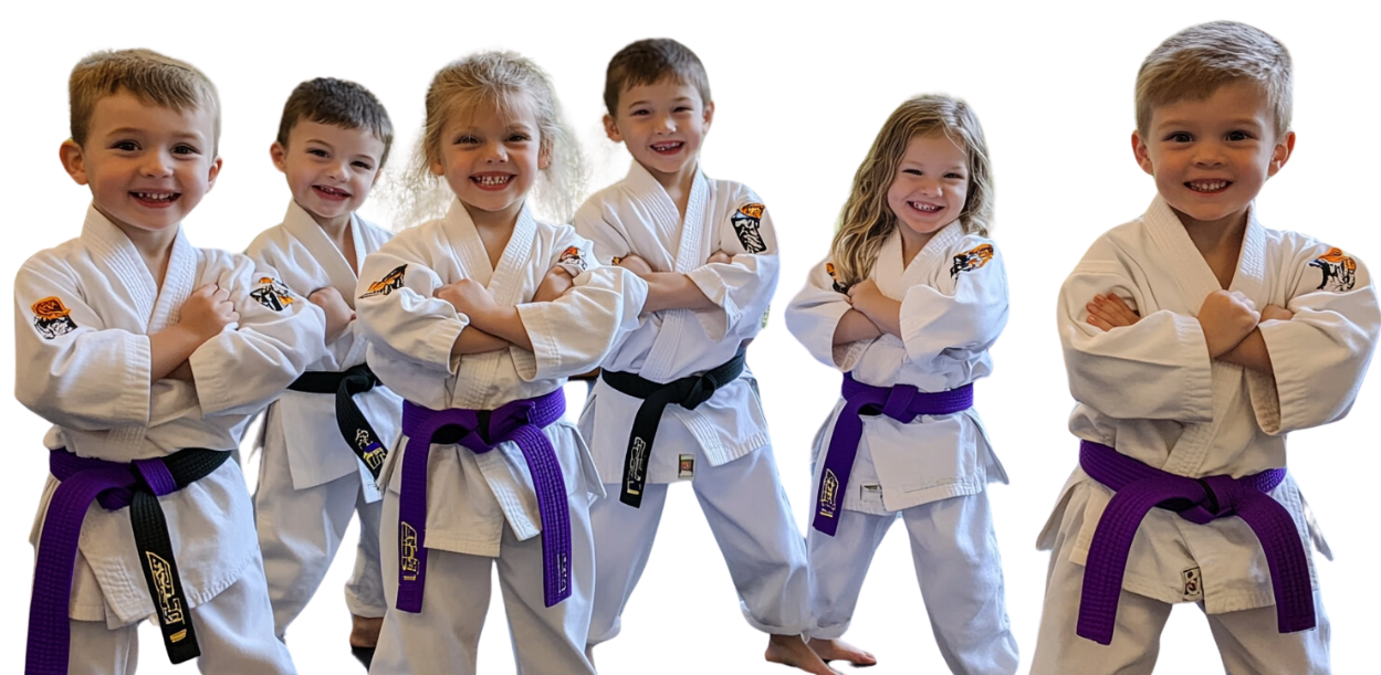 A group of young children wearing karate uniforms and purple belts.