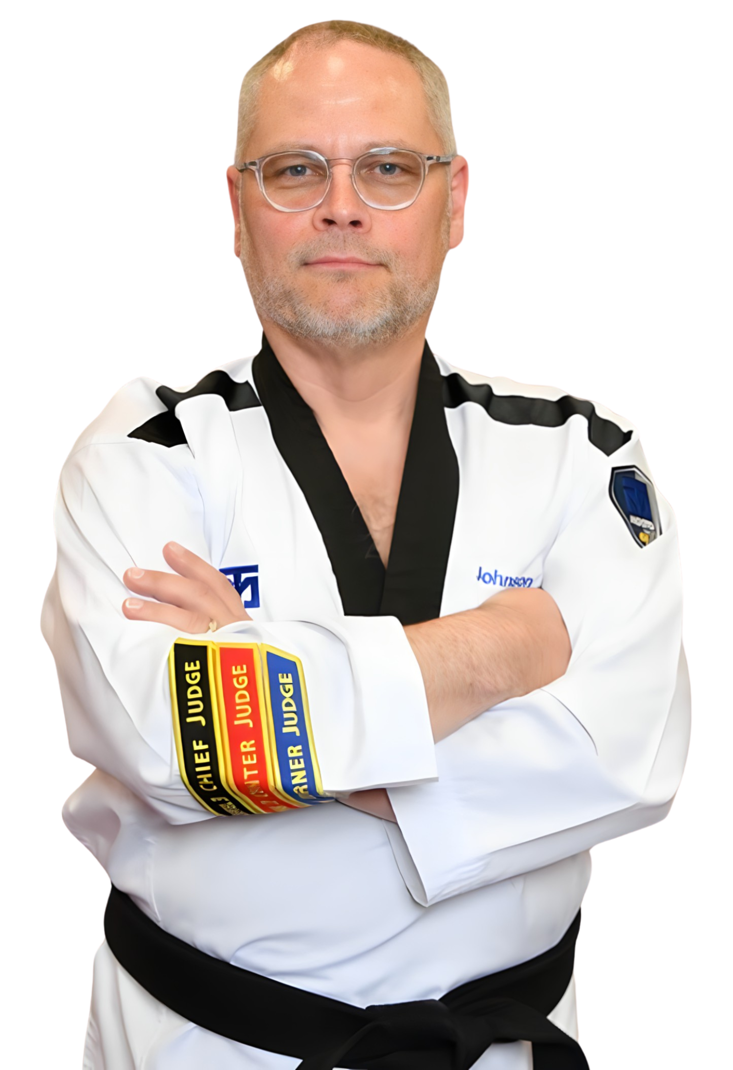 A man in a taekwondo uniform is standing with his arms crossed.