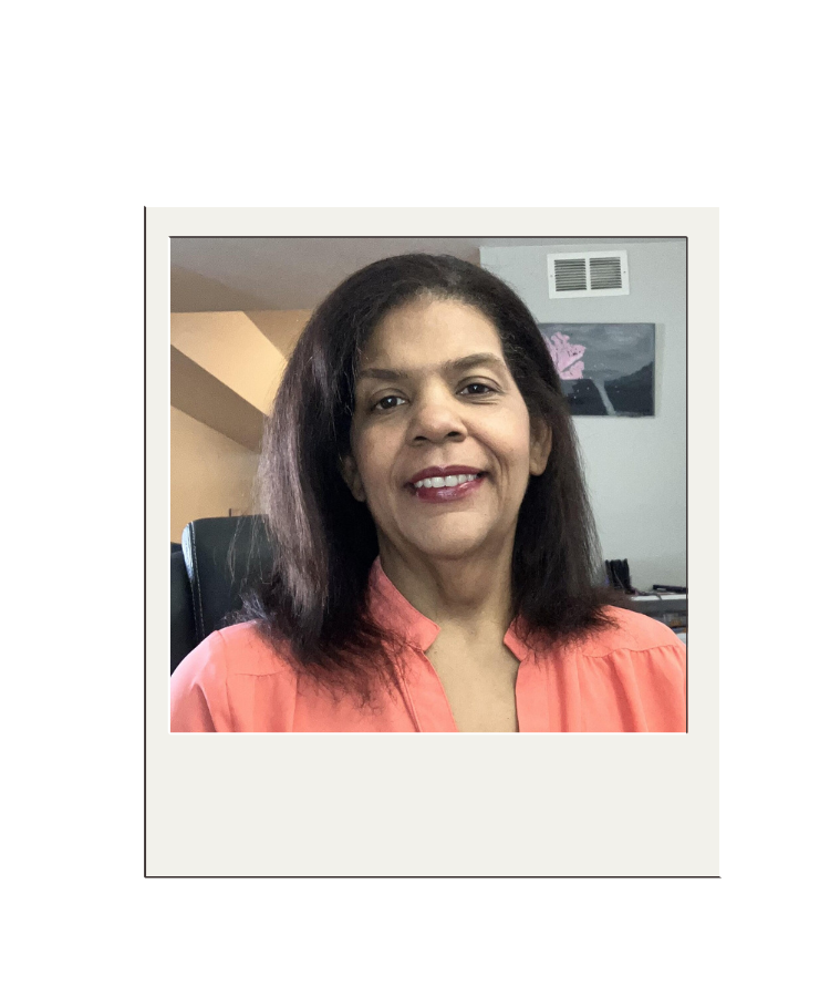 Owner and cruise specialist wearing coral color shirt smiling in home office