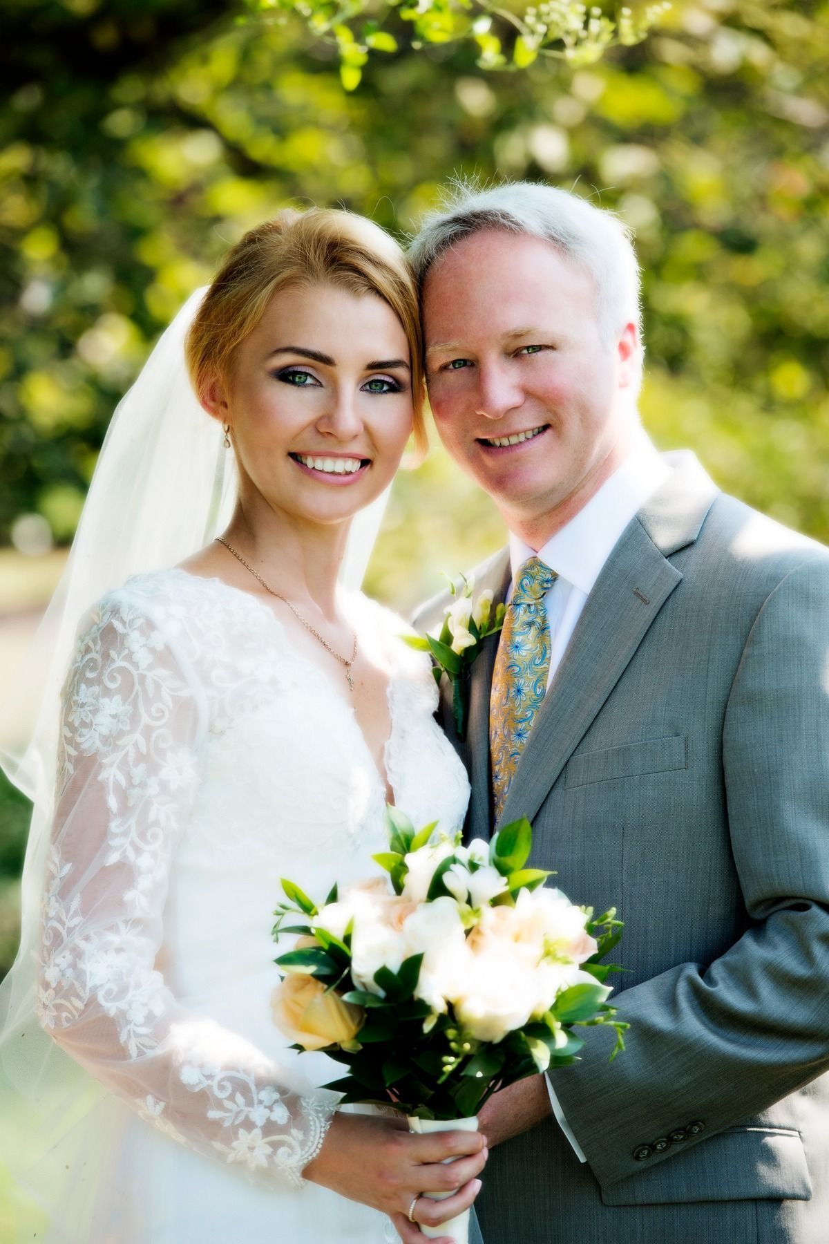 A bride and groom are posing for a picture on their wedding day.