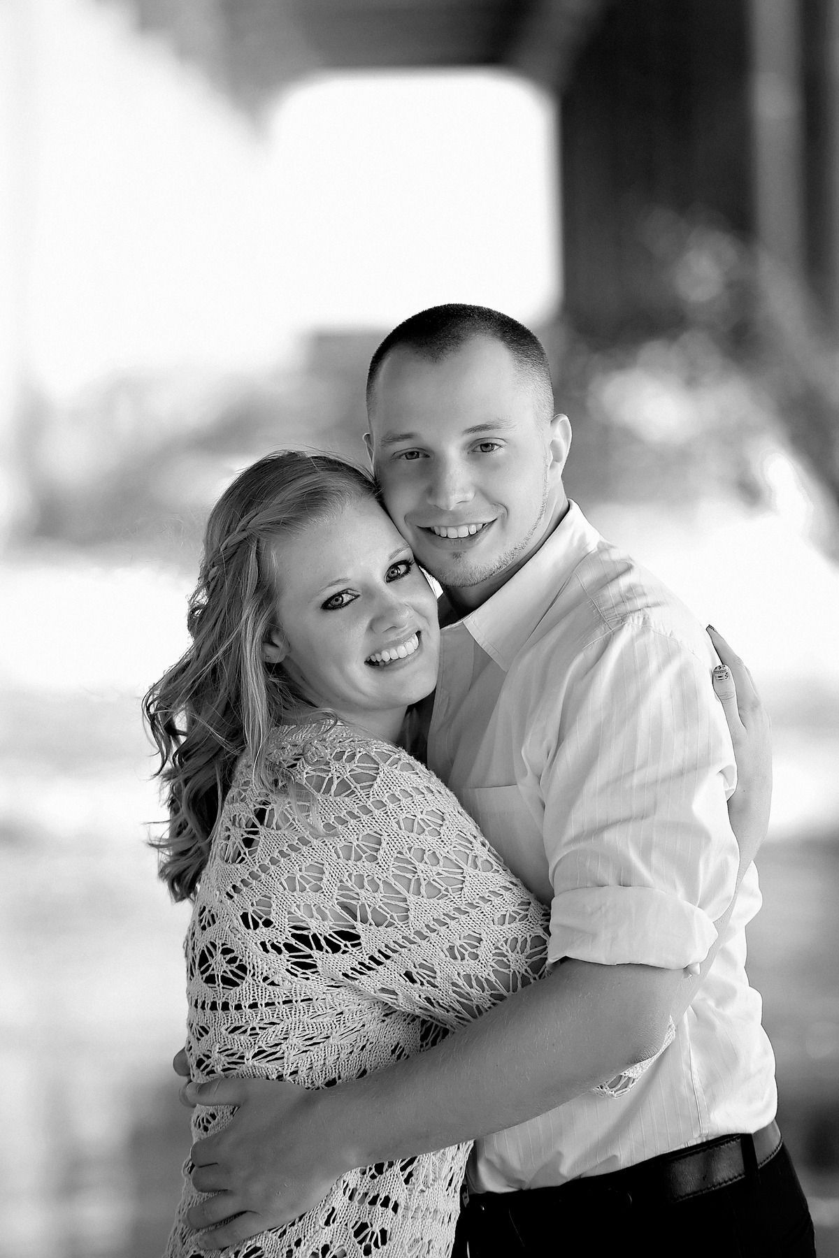 A man and a woman are hugging each other in a black and white photo.