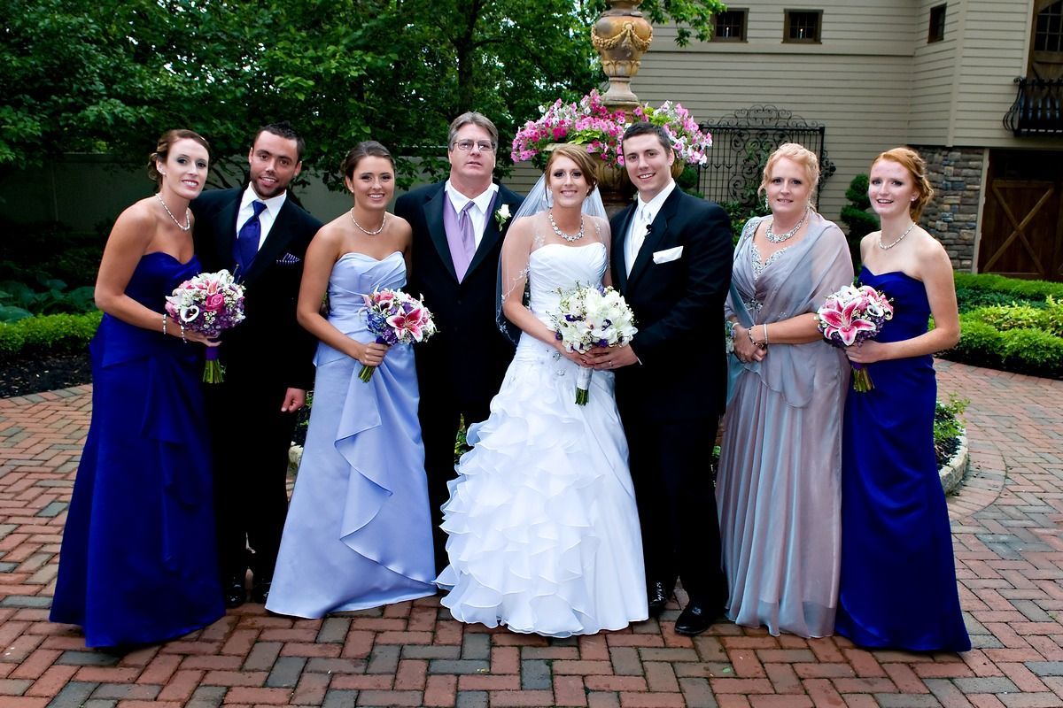 A bride and groom are posing for a picture with their wedding party.