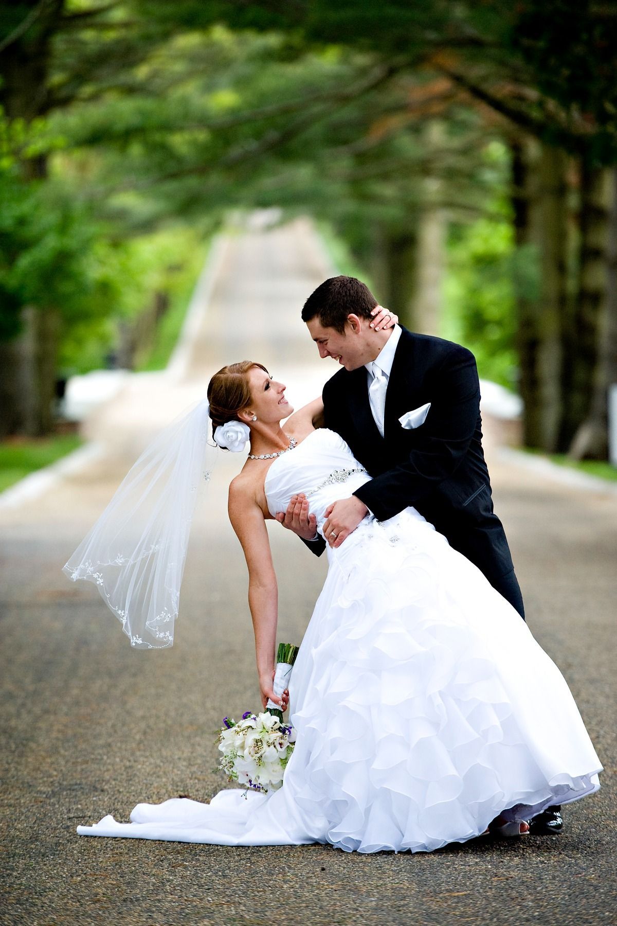 A bride and groom are posing for a picture on their wedding day.