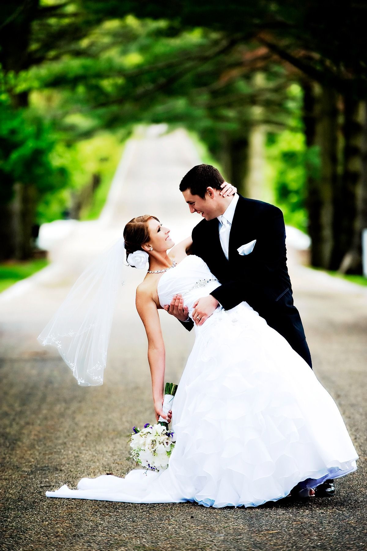 A bride and groom are posing for a picture on their wedding day