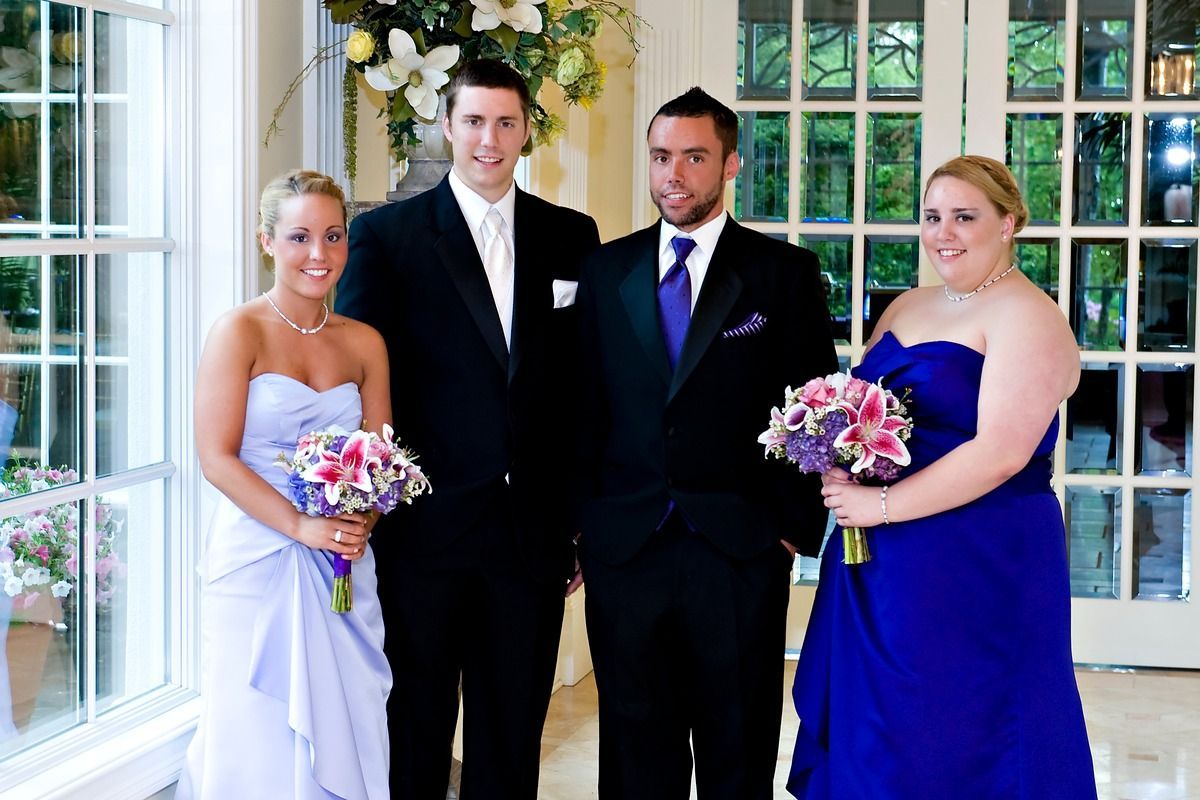 A bride and groom pose with their wedding party