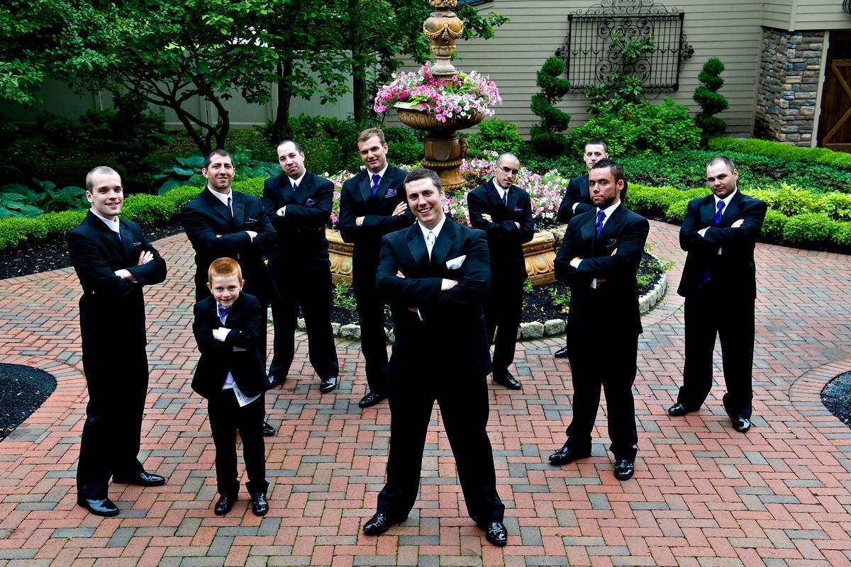 A group of men are posing for a picture in front of a fountain