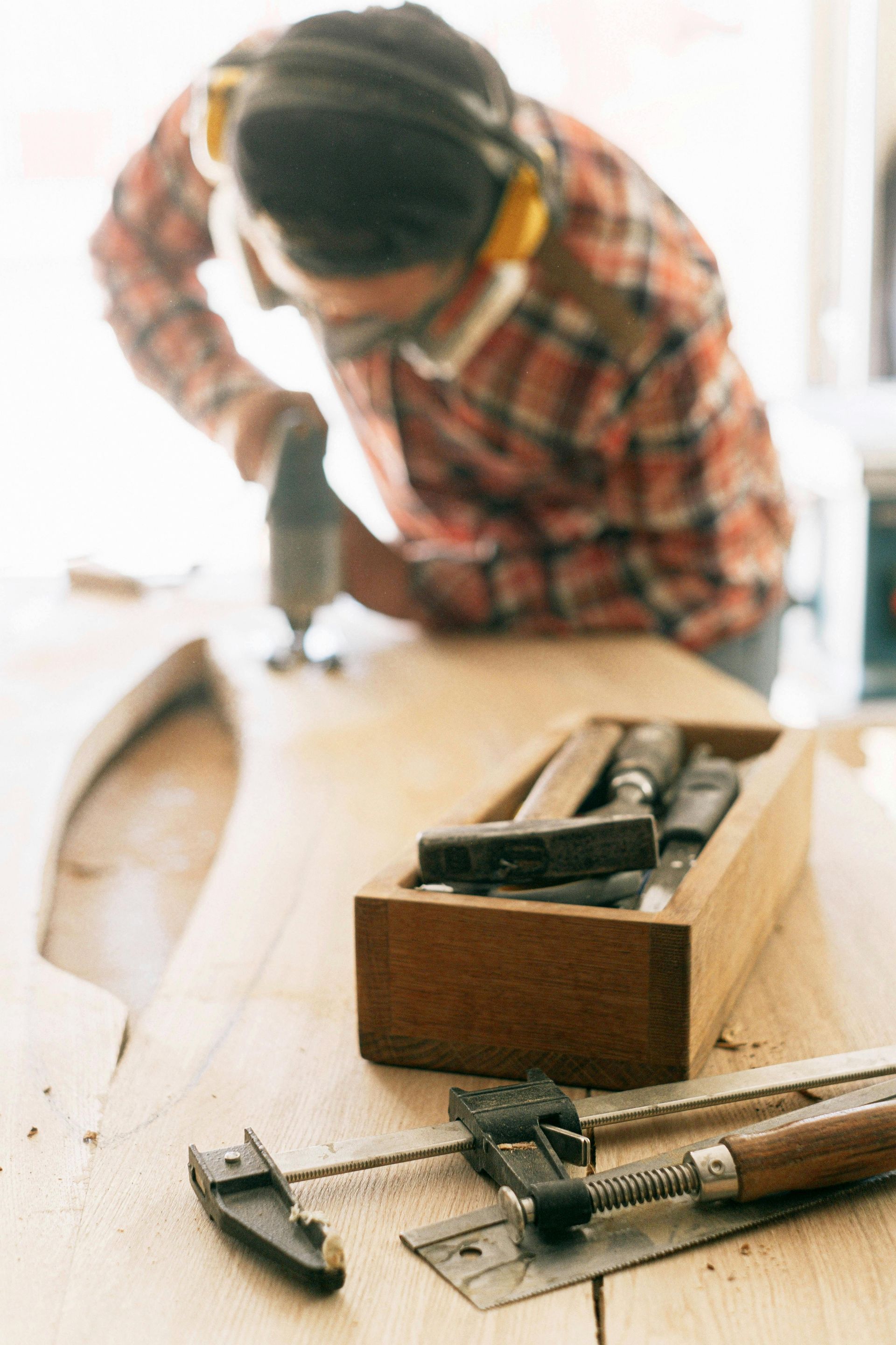 A man is using a drill on a piece of wood.