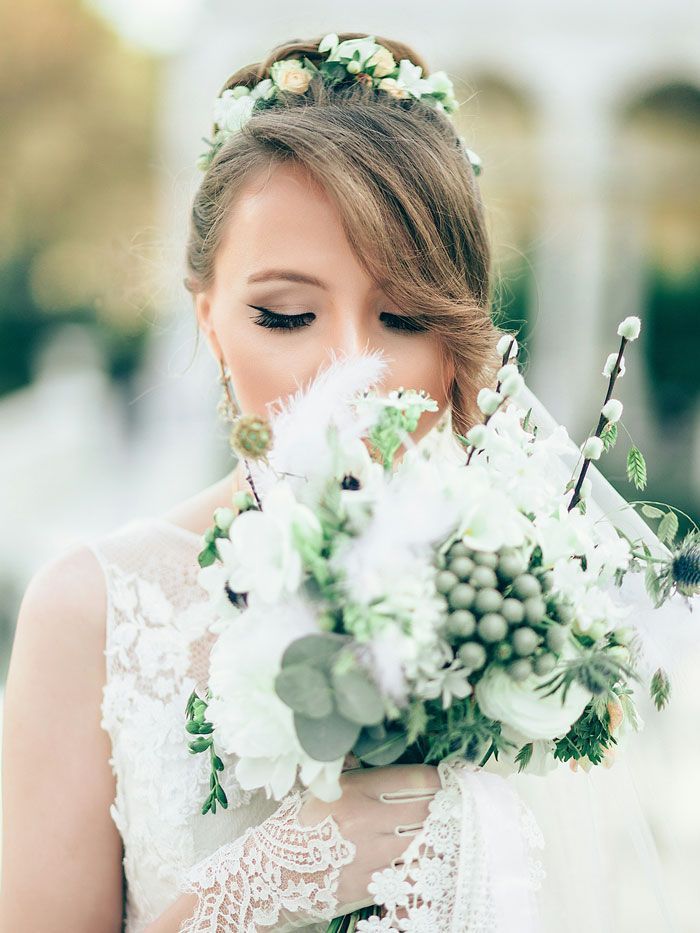 The bride is wearing a flower crown and holding a bouquet of white flowers.