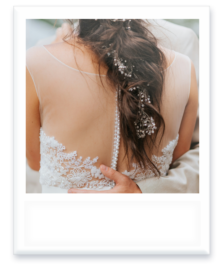 A bride in a wedding dress is being held by her groom