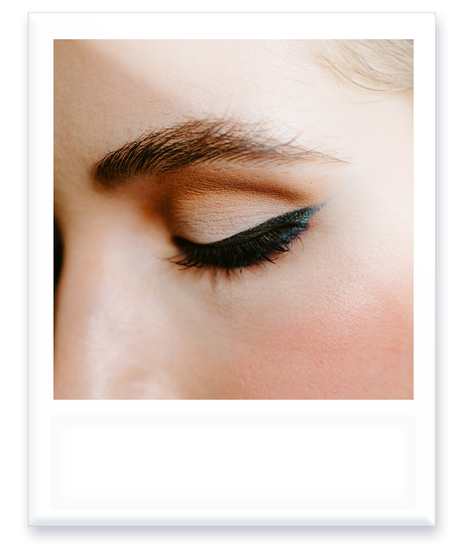 A close up of a woman 's eye with blue eyeliner