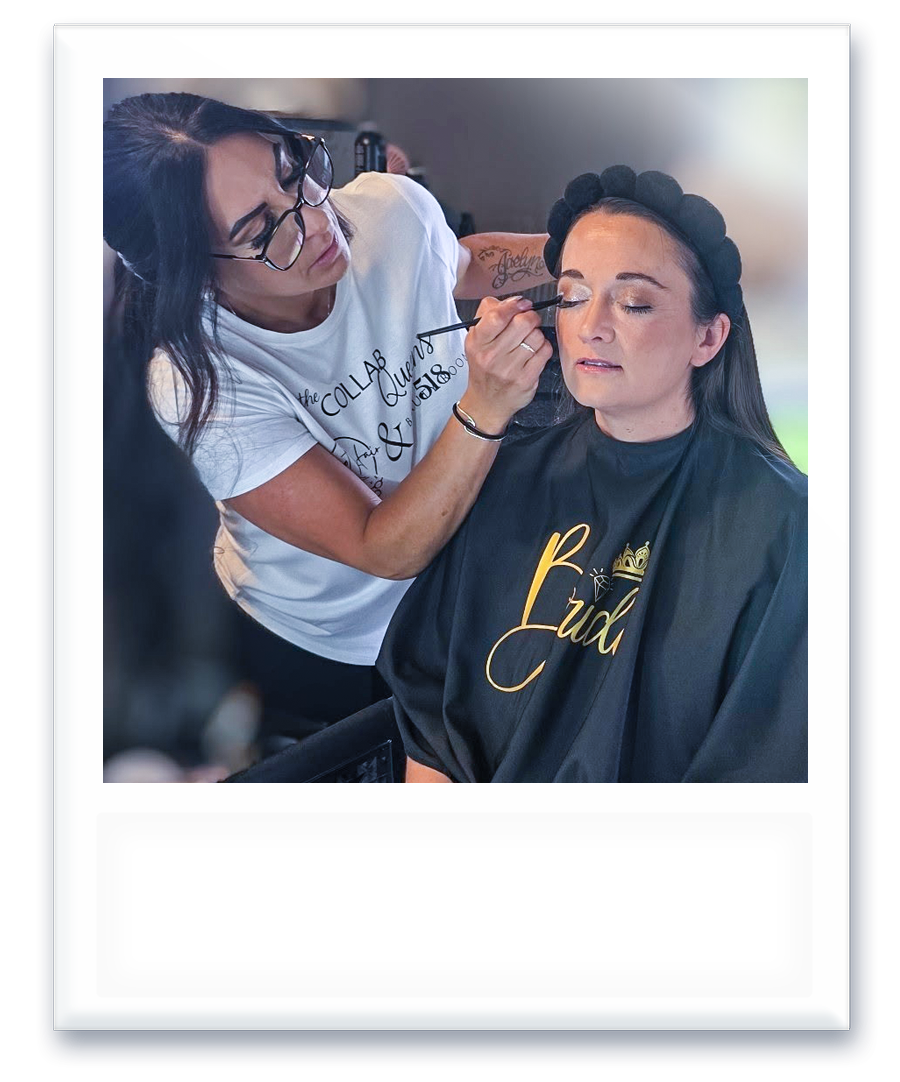 A woman is applying makeup to a bride 's face