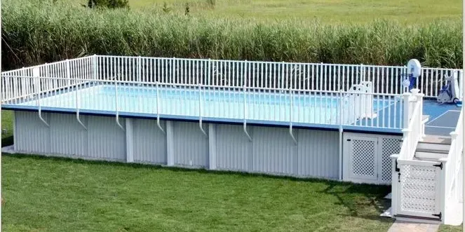 A large swimming pool with a white fence around it