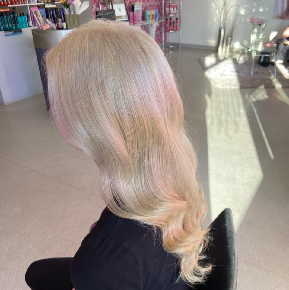 A Woman With Blonde Hair is Sitting in a Chair in a Salon — Cosmo Hair & Beauty In Nambour, QLD