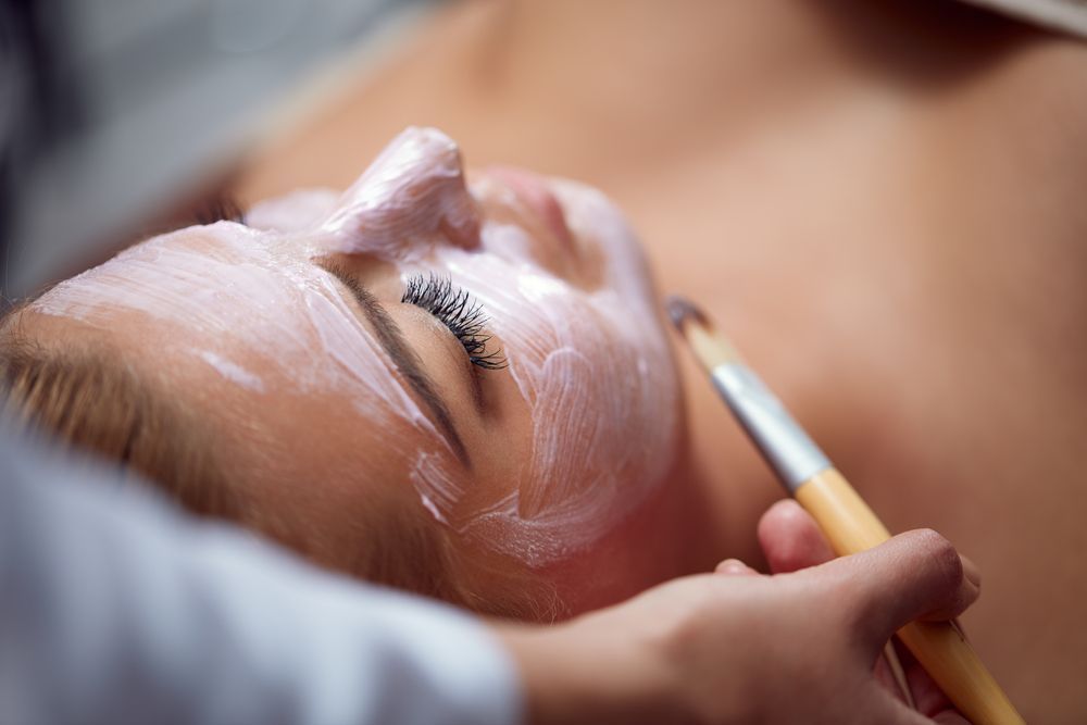 A Woman is Getting a Facial Treatment at a Spa — Cosmo Hair & Beauty In Nambour, QLD