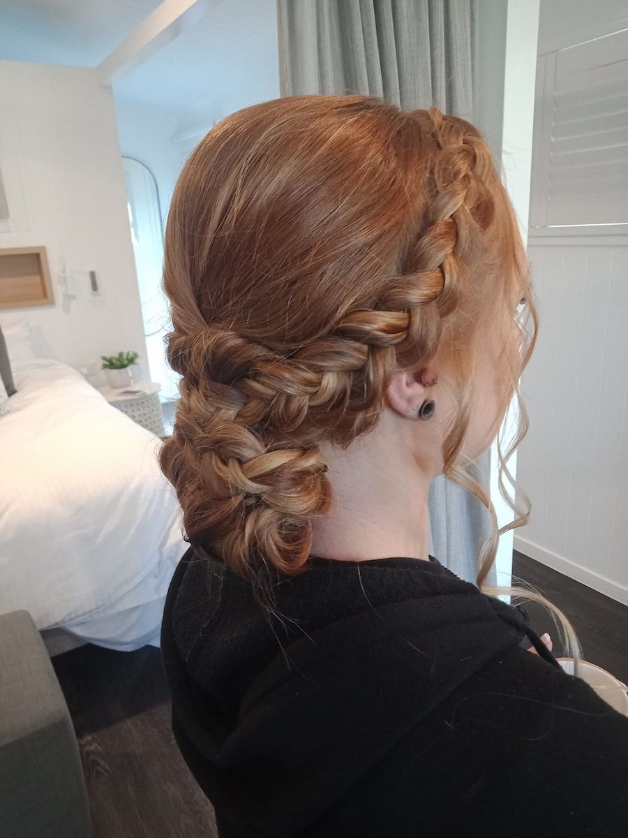 A Woman With Red Hair is Wearing a Braided Bun — Cosmo Hair & Beauty In Nambour, QLD