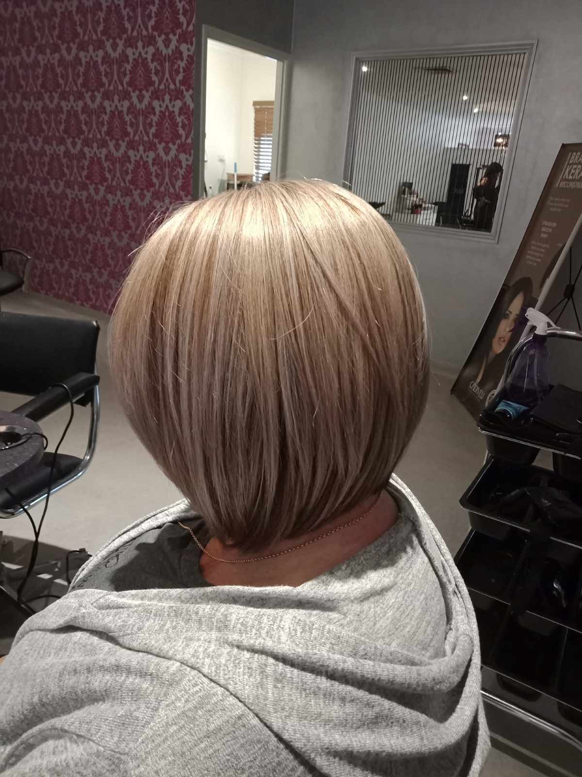 A Woman is Getting Her Hair Cut in a Salon — Cosmo Hair & Beauty In Nambour, QLD